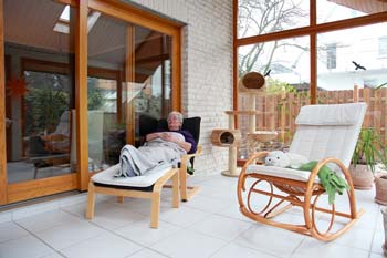 Older Homeowner Relaxing in an Enclosed Porch