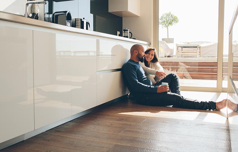 Couple sitting on Kitchen floor - About Popular Kitchen Flooring Materials